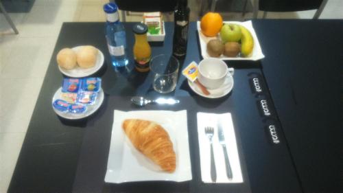a table topped with a plate of bread and fruit at Hotel Room in Pontevedra