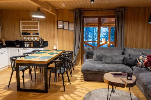 a kitchen and living room with a table and a couch at Dwa Pomosty in Augustów