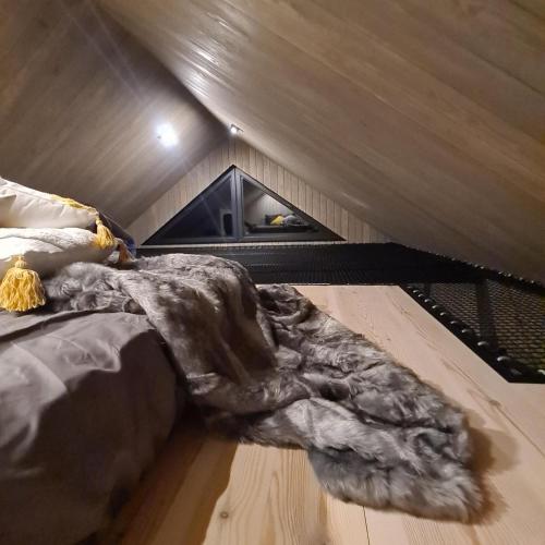 a bed in a room with a wooden floor at Dwa Pomosty in Augustów