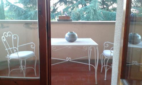 einen Tisch und zwei Stühle auf einer Veranda in der Unterkunft Lupo Azzurro in Siena