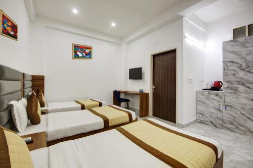 a hotel room with two beds and a television at Hotel SB Grand Inn - Paharganj in New Delhi