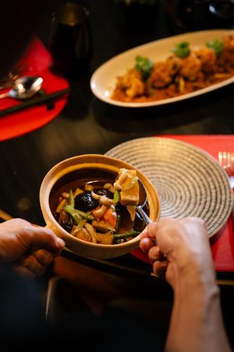 a person holding a bowl of food on a table at JW Marriott Hotel Kolkata in Kolkata