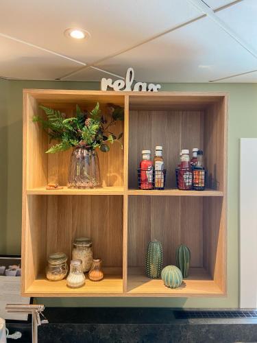 a wooden shelf with a vase of flowers on it at Good Morning Örebro in Örebro