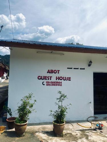 a guest house with potted plants in front of it at Abot guest house in Kuala Tahan