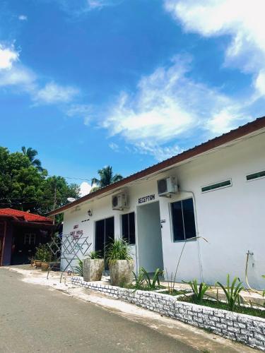 a white building with plants in front of it at Abot guest house in Kuala Tahan