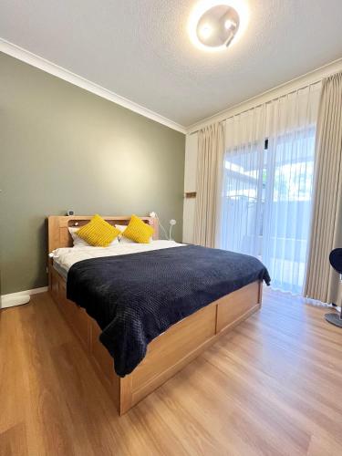 a bedroom with a large bed with yellow pillows at Parkview Apartments in Brisbane