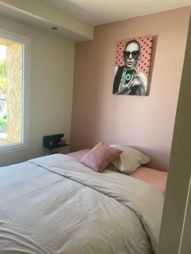 un dormitorio con una cama con una foto de un hombre con una cámara en La Vannerie de Livia, en Marmanhac