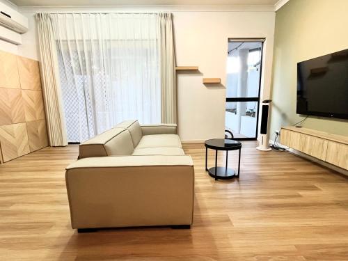 a living room with a couch and a flat screen tv at Parkview Apartments in Brisbane