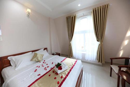 a bedroom with a bed with red rose petals on it at Thuận Hải Hotel PQ - by BAY LUXURY in Phu Quoc