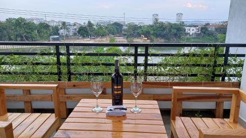 una botella de vino sentada en una mesa con dos copas en 2H Homestay, en Thôn Lại Thê