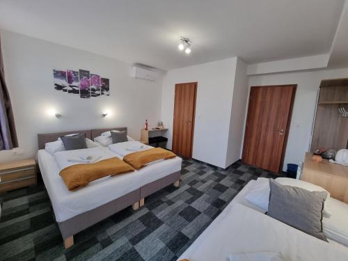 a bedroom with a large bed and a couch at Heléna Hotel & SPA in Levél