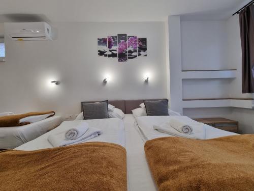 a bedroom with two beds with white sheets at Heléna Hotel & SPA in Levél