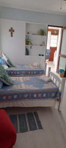 two beds in a room with a mirror at A1 Kynaston Guest House bed and breakfast or self catering in Jeffreys Bay