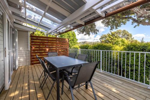 a patio with a table and chairs on a deck at Miami one one in Oneroa