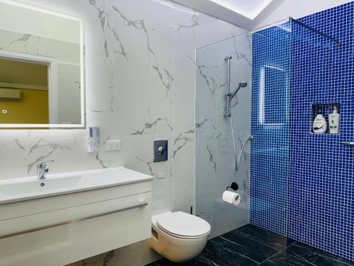 een badkamer met een toilet, een wastafel en een douche bij Colin's Garden in Bomaderry
