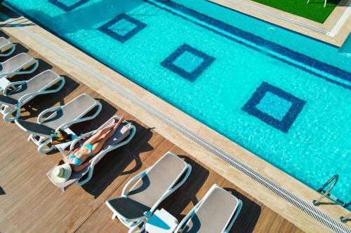 an overhead view of a pool with a row of chairs at Elysium Deluxe Suites Antalya in Antalya