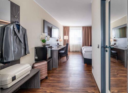 グレーヴェンブローホにあるBest Western PLAZA Hotel Grevenbroichのベッドとデスクが備わるホテルルームです。