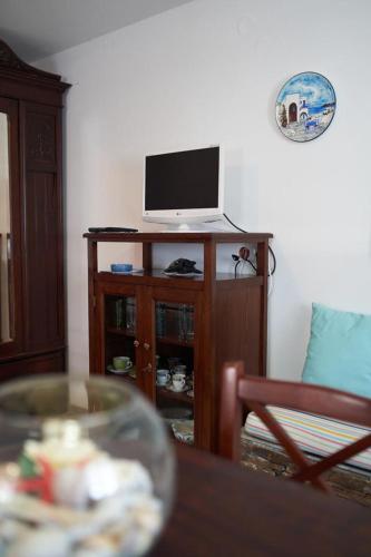 a living room with a table and a television on a cabinet at Tramontana Suites in Áyios Stéfanos