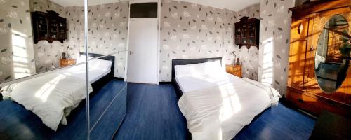 a bedroom with two white beds and a mirror at Double room near Highgate in London