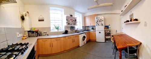 uma grande cozinha com uma mesa e um frigorífico em Double room near Highgate em Londres