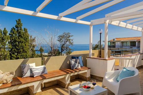 a patio with a bench and a view of the ocean at Naxos Loft in Giardini Naxos