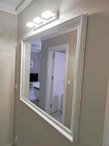 a mirror hanging on a wall in a bathroom at DiP HOME APARTMENTS in Pomorie