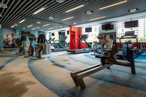 a gym with several treadmills and machines in a room at Panda Hotel in Hong Kong