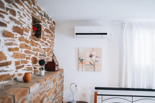 a living room with a brick wall and a fireplace at Tramontana Suites in Áyios Stéfanos