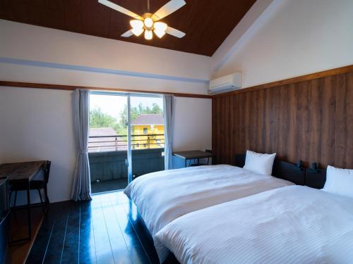a bedroom with a large bed and a window at 恩納Garden Resort Okinawa 希望が丘ビーチまで徒歩10分 in Inbu