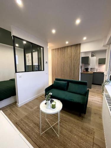 un salon avec un canapé vert et une table dans l'établissement HOME GREEN TOUCH - Fibre*Near Basel*Cosy, à Saint-Louis