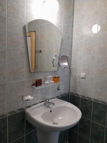 a bathroom with a sink and a mirror at Аурелия Бей in Ravda