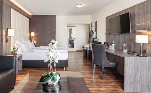 Best Western PLAZA Hotel Grevenbroich في غرفنبرويش: غرفة في الفندق مع سرير ومكتب