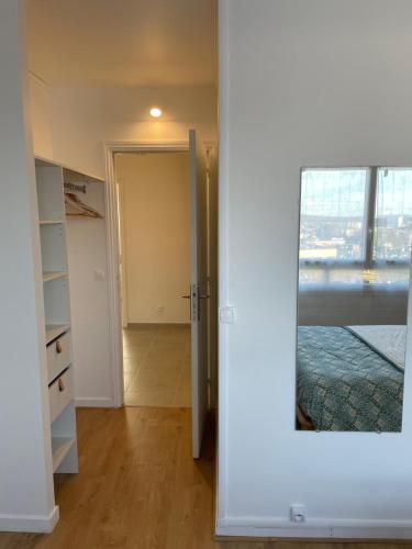 ein leeres Zimmer mit einer Tür und einem Spiegel in der Unterkunft Coliving - chambre jaune in Sarcelles