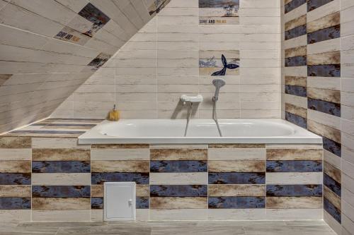 baño con bañera y pared de azulejos en CasadinFeleacu en Feleacu