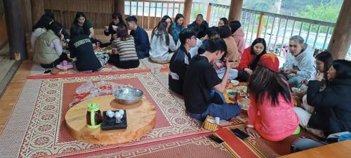 a group of people sitting on the floor eating food at Homestay duy mạnh gần suối nước khoáng nóng trạm tấu in Cham Ta Lao