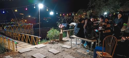 a group of people sitting around a fence at night at Homestay duy mạnh gần suối nước khoáng nóng trạm tấu in Cham Ta Lao