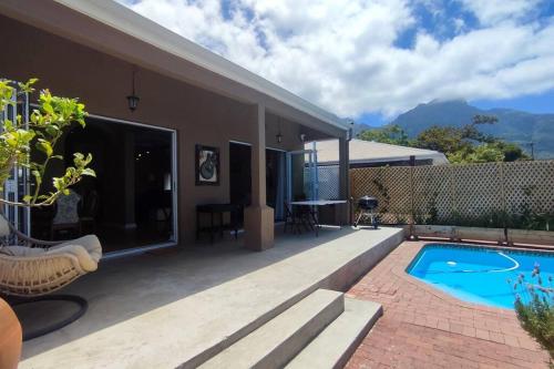 a house with a swimming pool and a patio at Scenic house with splash pool in Cape Town