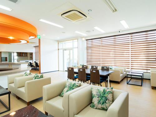 a living room with couches and a table and chairs at 恩納Garden Resort Okinawa 希望が丘ビーチまで徒歩10分 in Inbu