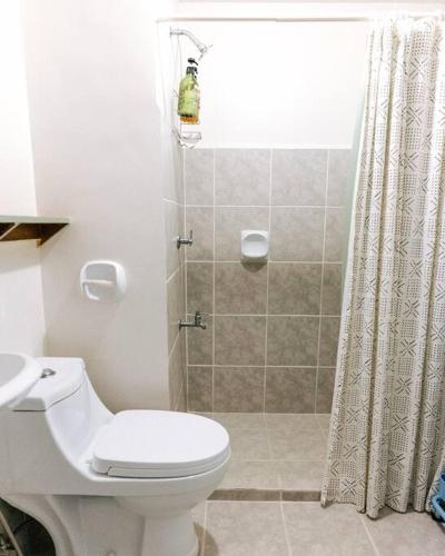ein Badezimmer mit weißer Toilette und Dusche in der Unterkunft Siesta Studio in Bacolod City
