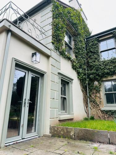 a white house with a large glass door at Glenastar Lodge in Newcastle West