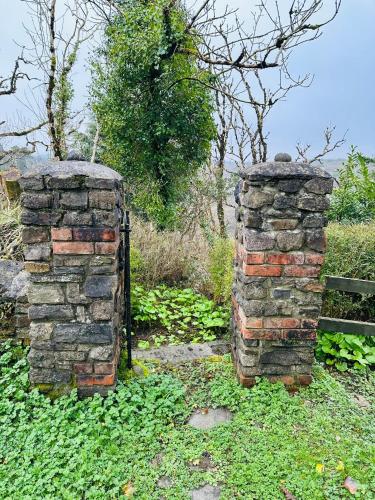 two old brick walls sitting next to a fence at Glenastar Lodge in Newcastle West