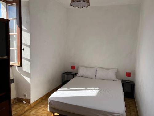 - un lit blanc dans une chambre avec deux tables dans l'établissement Maison de Campagne au bord de l'eau, à Saint Alban Auriolles