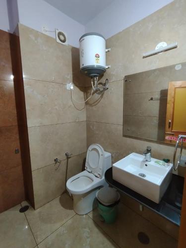 a bathroom with a toilet and a sink and a light at Pranays House in Mumbai