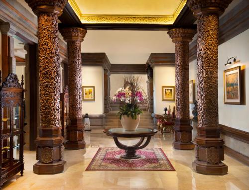 a lobby with columns and a table with flowers at The Ayodya Palace in Nusa Dua