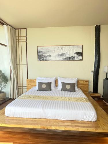 a bedroom with a large bed with white sheets and pillows at Sunset room in Ban Huai Khai