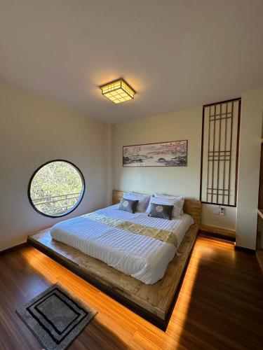 a bedroom with a large bed with a large window at Sunset room in Ban Huai Khai