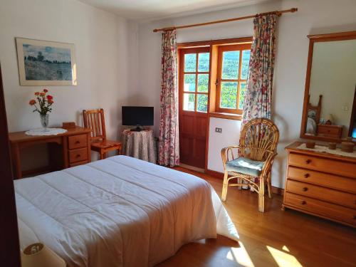 Schlafzimmer mit einem Bett, einem Schreibtisch und einem Fenster in der Unterkunft San Felipe House With Views Of Teide in Icod de los Vinos