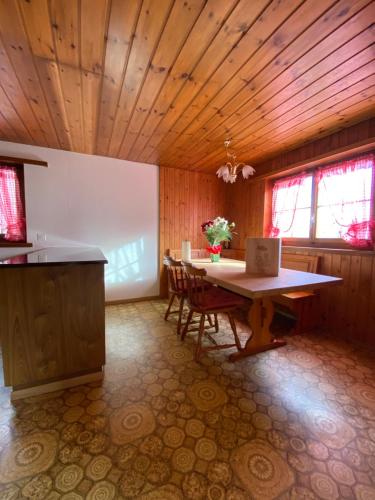 a kitchen with a table and chairs in a room at Casa Plaun Martin in Ruschein