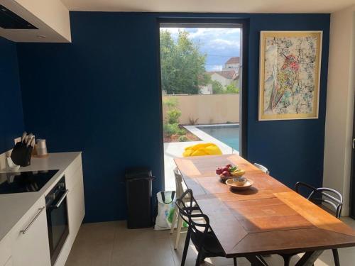 普瓦捷的住宿－Beautiful family home，厨房配有木桌和蓝色的墙壁