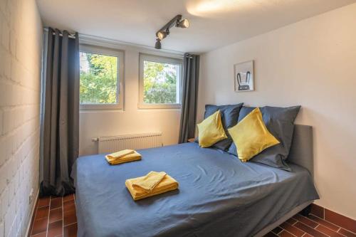 a bedroom with a blue bed with two yellow pillows at Hamburg City Apartment in Hamburg